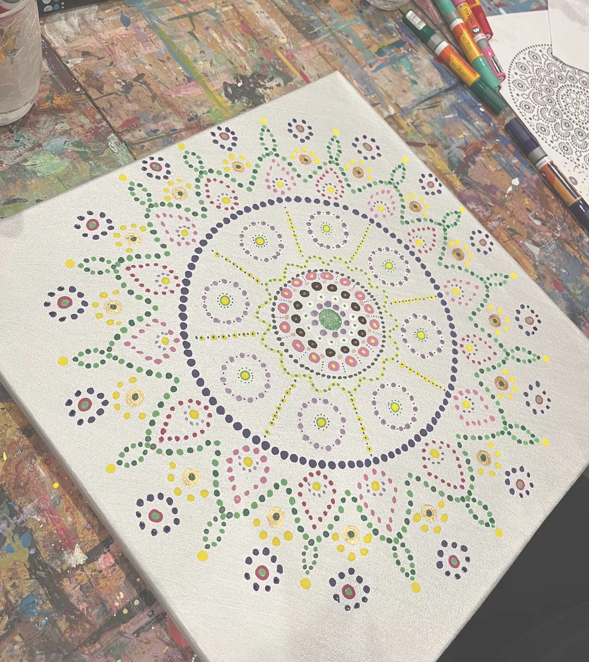 Mandala aus farbigen Punkten auf weißer Leinwand