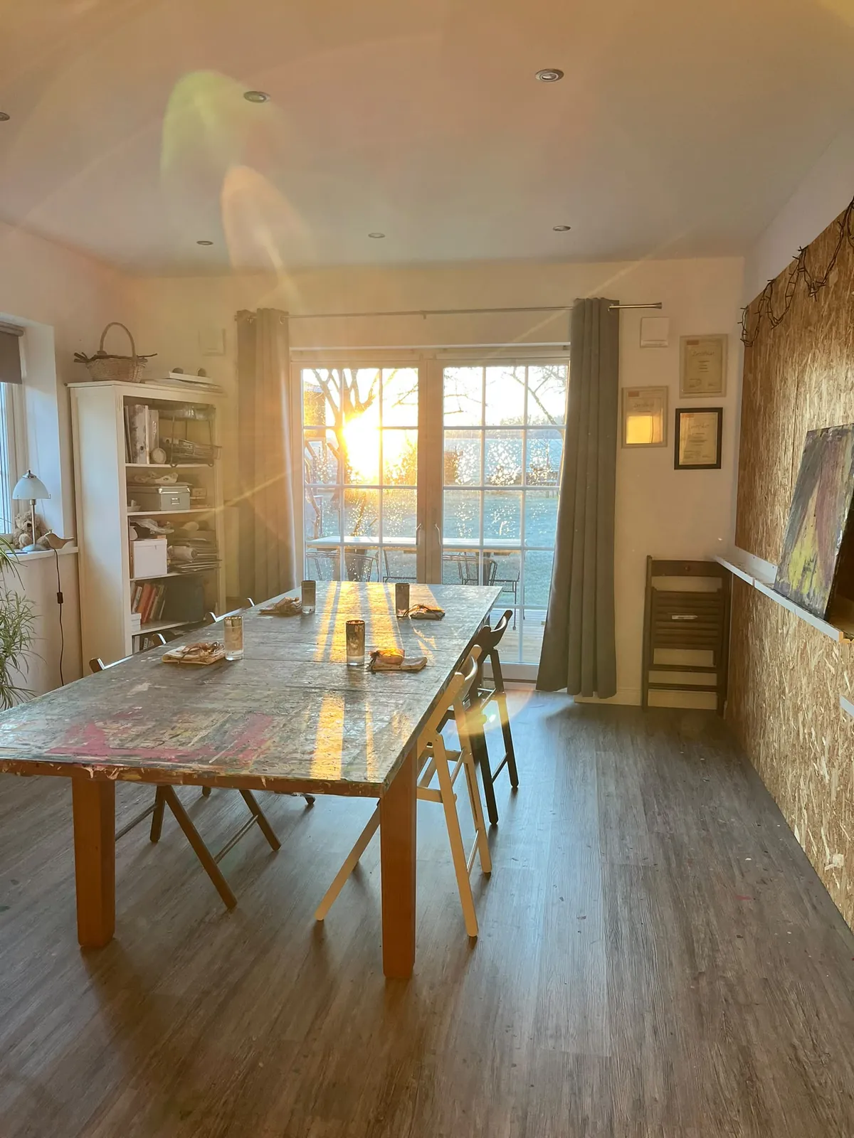 Atelierraum im Abendlicht mit großem Holztisch